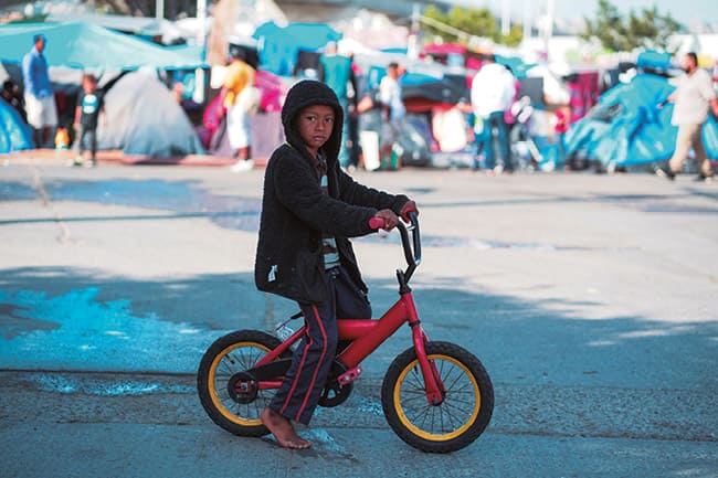 Niña montando una bicicleta roja durante el día, símbolo de esperanza y movimiento en la vida cotidiana.