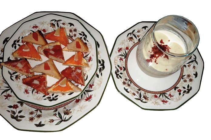 Crema fría de melón con jamón pulverizado y canapés variados presentados en copa y plato.