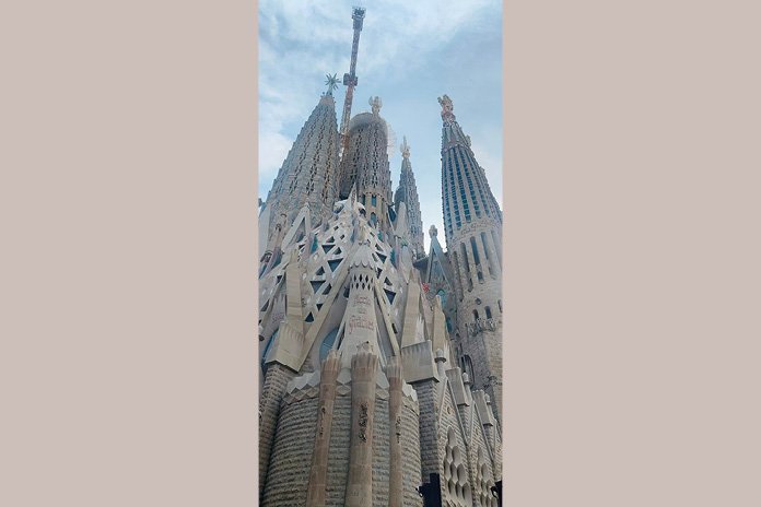 Fachada monumental de la Sagrada Familia de Barcelona con sus torres y detalles simbólicos al atardecer