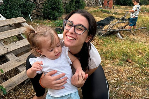 Ángela cuida a una niña pequeño en el Aula Familiar Tomás Morales.