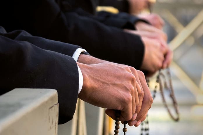 Manos sosteniendo un rosario en oración como signo de devoción mariana.