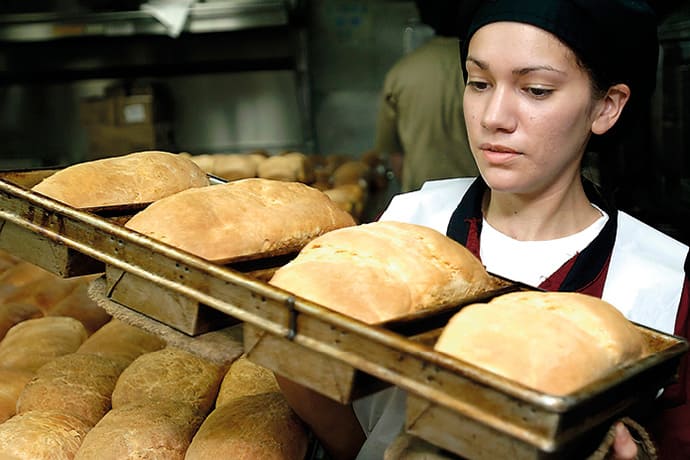 Trabajadora en un horno de pan mostrando esfuerzo y dedicación en su labor diaria.