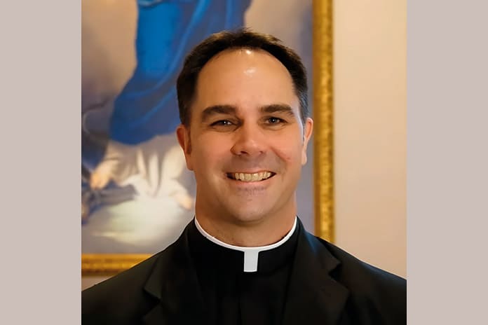 Donald Calloway vestido con hábito sacerdotal, sonriendo